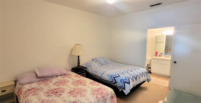 bedroom with light carpet, connected bathroom, and sink