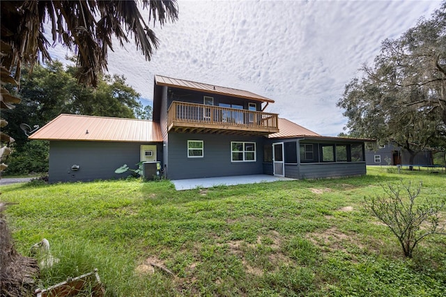 back of property with a trampoline, a patio, central AC unit, a yard, and a balcony