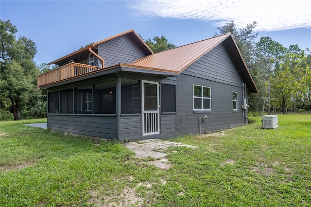 view of side of property featuring a lawn and a sunroom