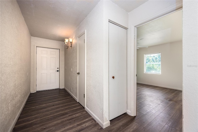 hall featuring a textured ceiling and dark hardwood / wood-style floors