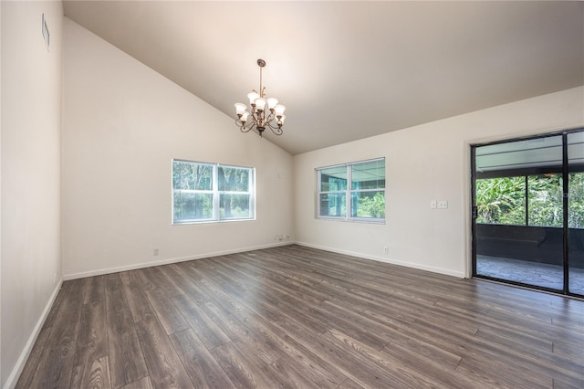 empty room with a notable chandelier, high vaulted ceiling, and dark hardwood / wood-style floors