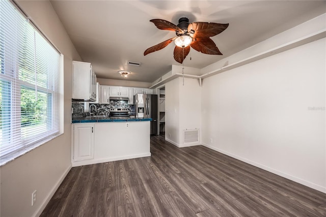 kitchen with white cabinetry, tasteful backsplash, dark hardwood / wood-style flooring, stainless steel appliances, and ceiling fan