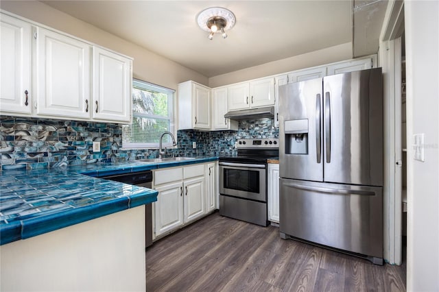 kitchen with sink, white cabinetry, stainless steel appliances, tile counters, and dark hardwood / wood-style flooring