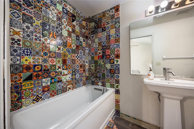 bathroom featuring tiled shower / bath and hardwood / wood-style floors