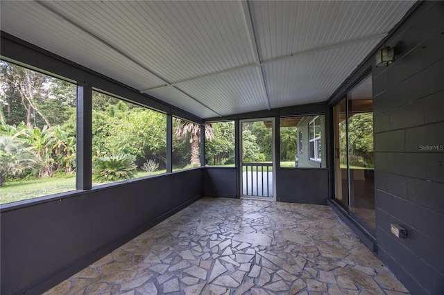 unfurnished sunroom with plenty of natural light and vaulted ceiling