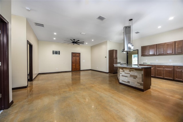 kitchen with hanging light fixtures, a center island with sink, ceiling fan, and island range hood