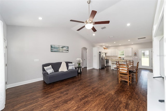 living room with ceiling fan, vaulted ceiling, and dark hardwood / wood-style flooring