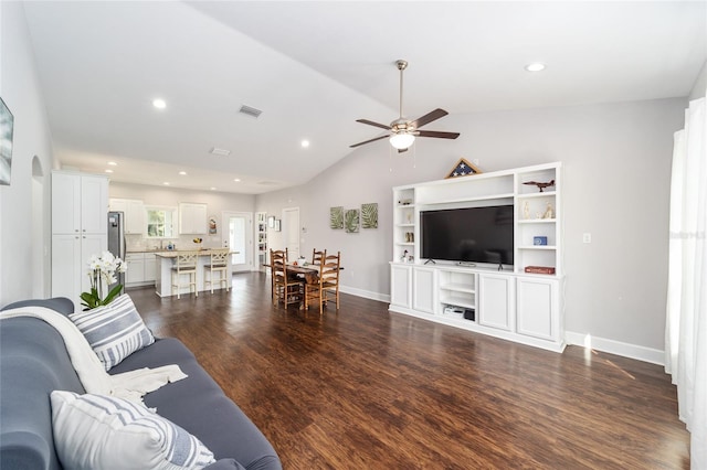 living room featuring ceiling fan, dark wood-type flooring, and vaulted ceiling