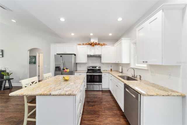 kitchen featuring white cabinets, sink, a kitchen island, stainless steel appliances, and dark hardwood / wood-style floors