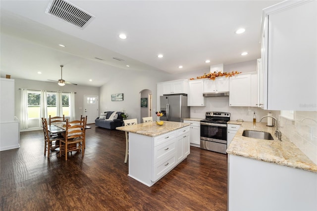 kitchen with ceiling fan, sink, appliances with stainless steel finishes, a center island, and vaulted ceiling