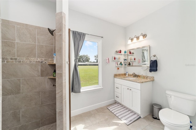 bathroom with vanity, tile patterned flooring, toilet, and tiled shower