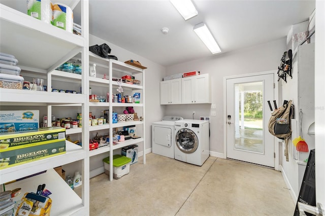 washroom with washer and dryer and cabinets