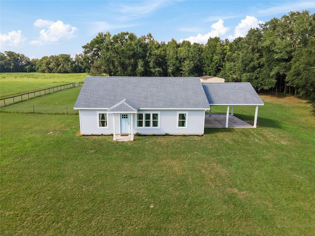 single story home featuring a front lawn, a patio, and a rural view