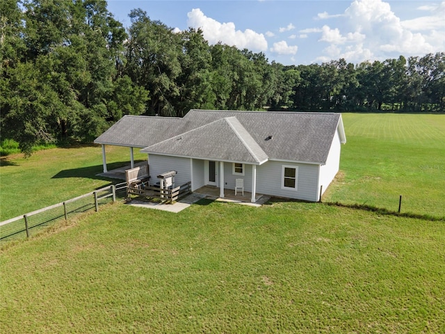 view of front of house with a rural view, a patio, and a front yard