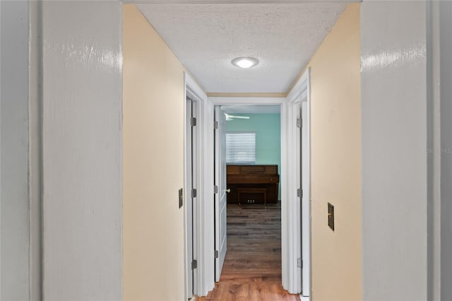 hall with hardwood / wood-style flooring and a textured ceiling