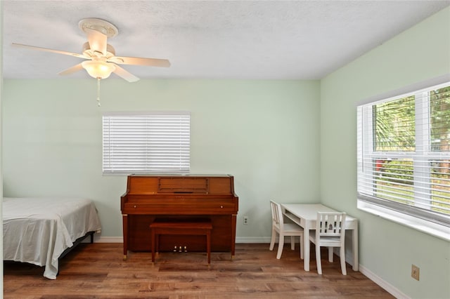 bedroom with wood-type flooring, a textured ceiling, and ceiling fan