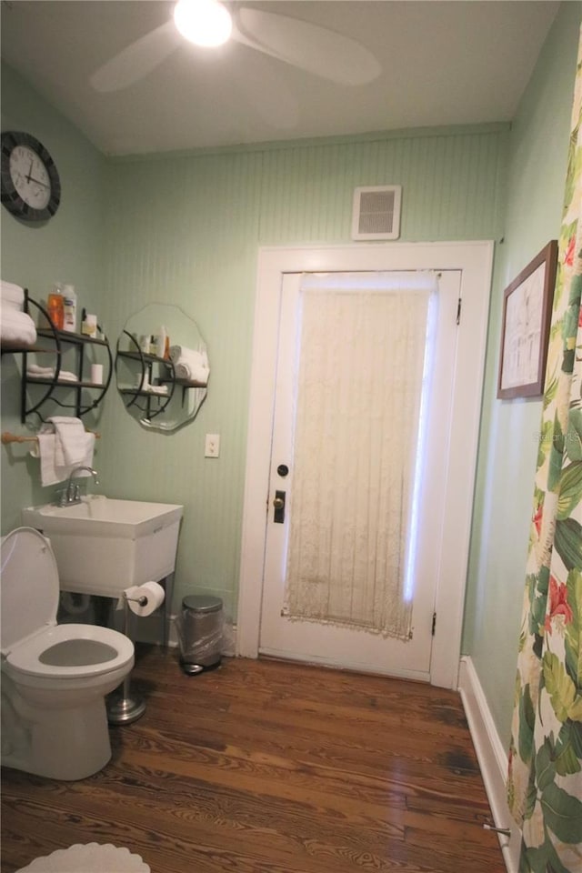 bathroom featuring toilet, hardwood / wood-style floors, and ceiling fan