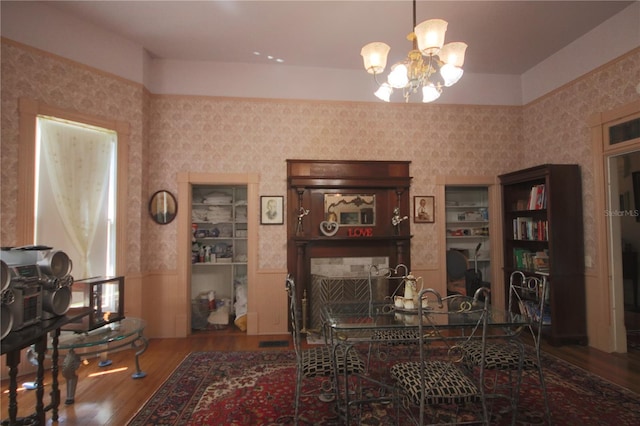 dining area with wood-type flooring and a notable chandelier