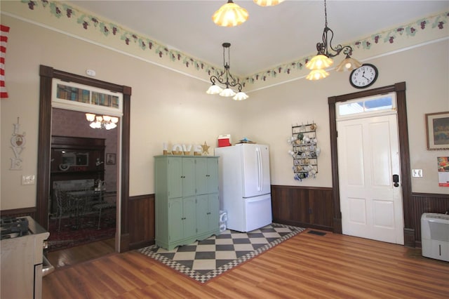 washroom with hardwood / wood-style flooring, wood walls, and a notable chandelier