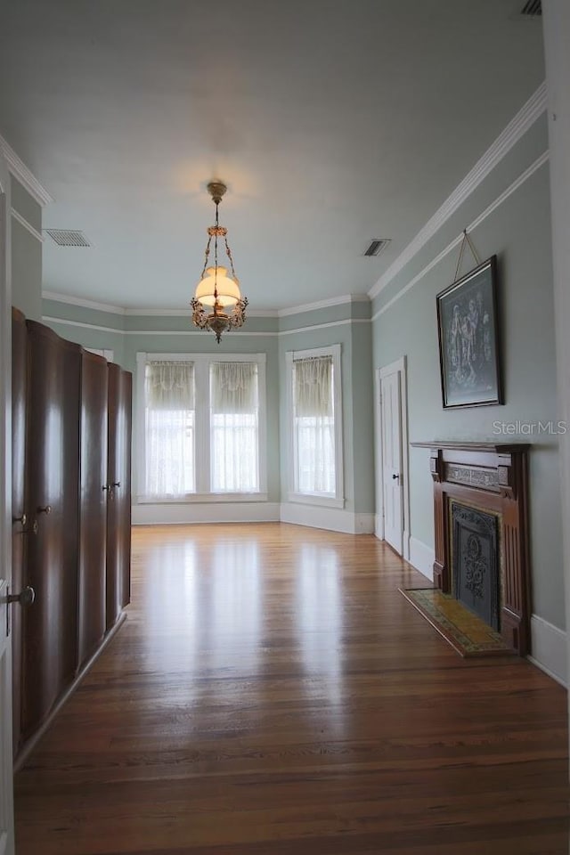 unfurnished living room featuring ornamental molding, a chandelier, and hardwood / wood-style floors