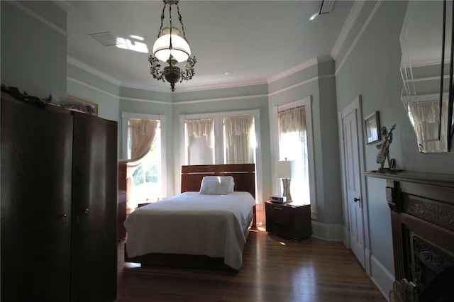 bedroom featuring crown molding, dark wood-type flooring, and multiple windows