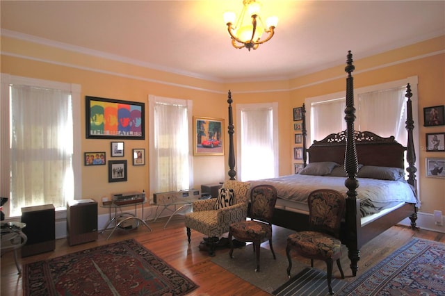 bedroom with wood-type flooring, a notable chandelier, and ornamental molding