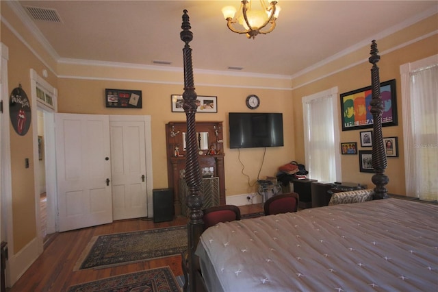 bedroom with hardwood / wood-style flooring, crown molding, and a notable chandelier