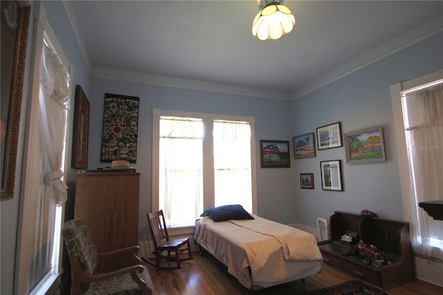 bedroom with ornamental molding and dark hardwood / wood-style flooring