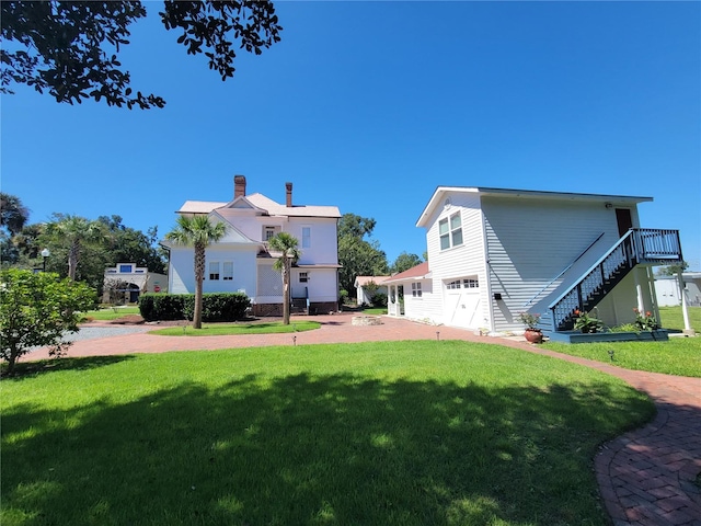 back of property featuring a lawn and a garage