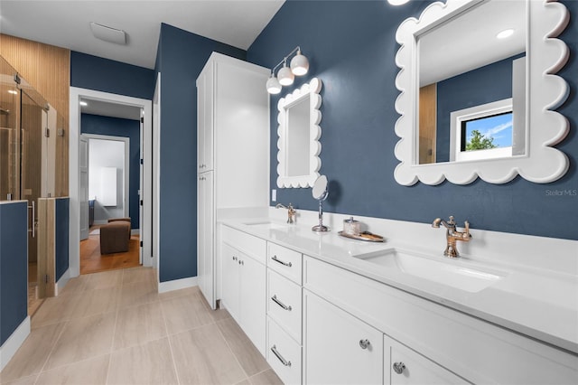 bathroom featuring double vanity, a shower stall, tile patterned floors, and a sink