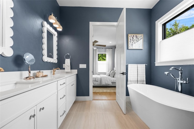ensuite bathroom with a freestanding bath, double vanity, ensuite bath, and a sink