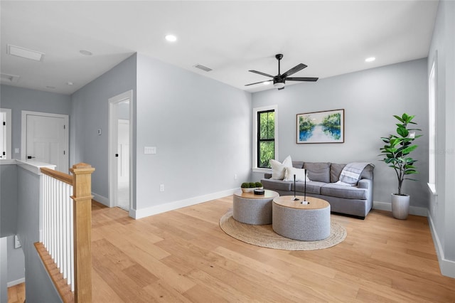 living area with light wood-type flooring, baseboards, visible vents, and ceiling fan