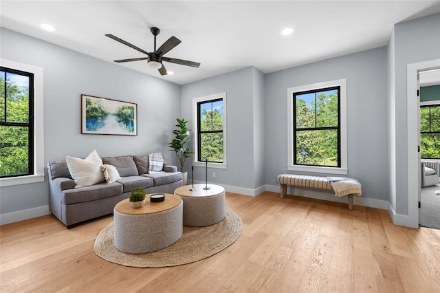 living area featuring light wood-style flooring, baseboards, recessed lighting, and a ceiling fan
