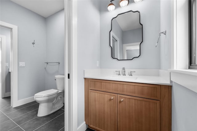 bathroom featuring toilet, vanity, tile patterned floors, and baseboards