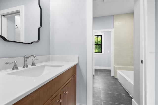 bathroom with vanity, baseboards, tile patterned flooring, and a bathing tub