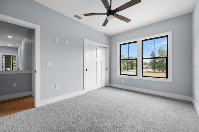 unfurnished bedroom featuring visible vents, baseboards, and multiple windows