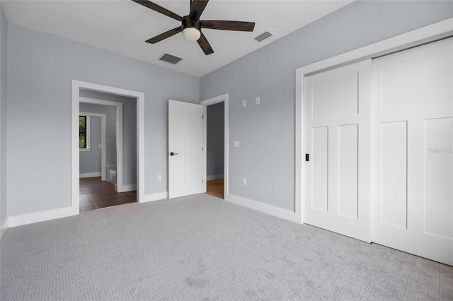 unfurnished bedroom featuring baseboards, a ceiling fan, visible vents, and carpet flooring