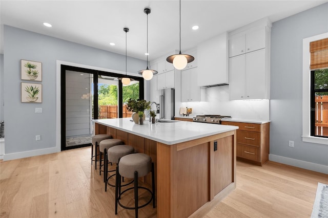 kitchen featuring light wood finished floors, baseboards, and a breakfast bar area