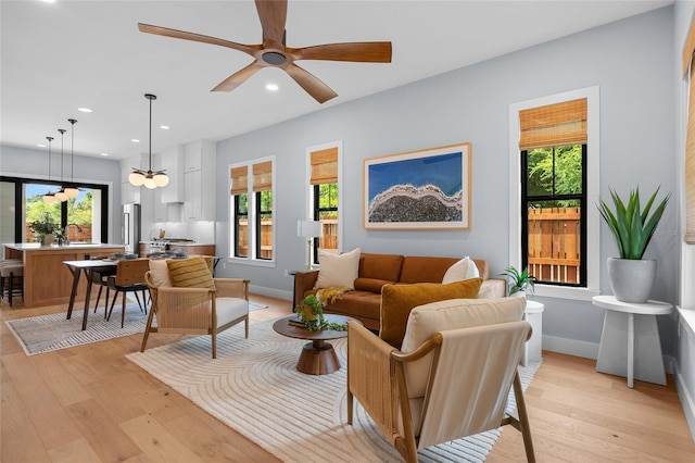 living area featuring recessed lighting, a wealth of natural light, a ceiling fan, and light wood-type flooring