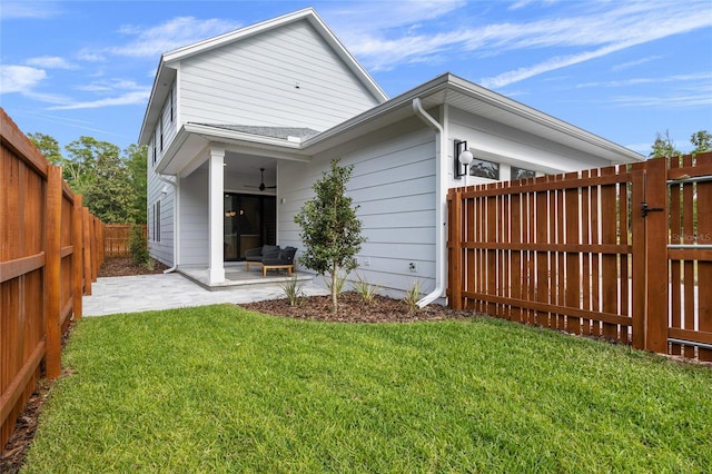 rear view of property featuring a patio area, a lawn, a fenced backyard, and ceiling fan
