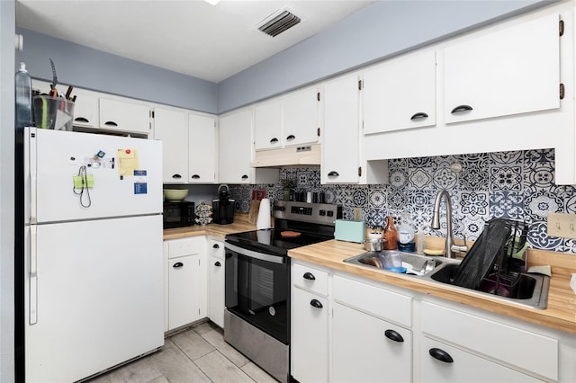 kitchen featuring white cabinets, tasteful backsplash, white refrigerator, and stainless steel electric stove