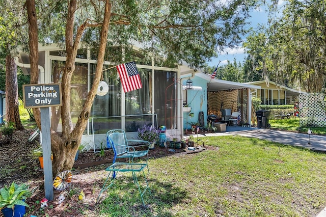 exterior space featuring a lawn, a sunroom, and a carport