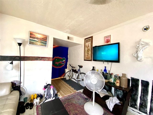 living room featuring a textured ceiling and ornamental molding