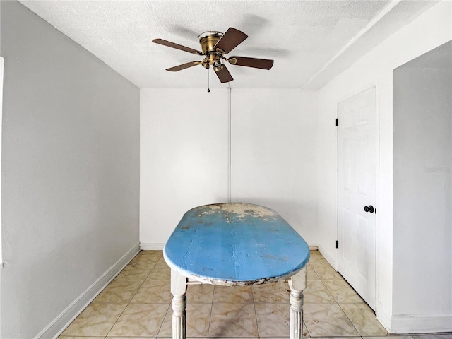 interior space featuring light tile patterned flooring, ceiling fan, and a textured ceiling