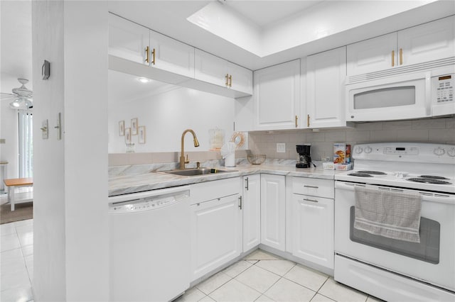 kitchen with light tile patterned flooring, tasteful backsplash, sink, white cabinets, and white appliances