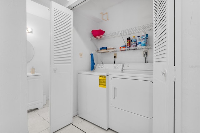 laundry room with independent washer and dryer and light tile patterned flooring