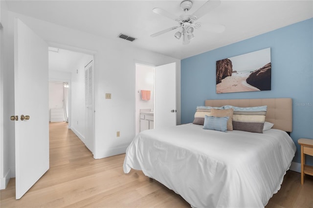 bedroom with ceiling fan, light wood-type flooring, and connected bathroom