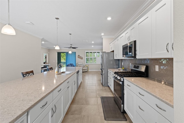 kitchen featuring white cabinets, stainless steel appliances, hanging light fixtures, and sink