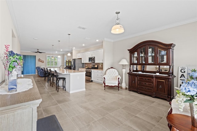 tiled living room with ornamental molding and ceiling fan