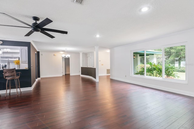 unfurnished living room with ceiling fan with notable chandelier, crown molding, and dark hardwood / wood-style floors